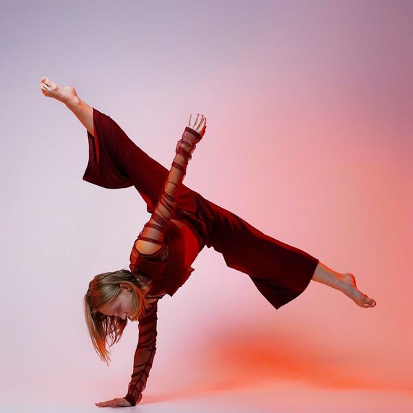 Woman performing an energetic yoga flow with a bright background.